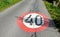 Speed limit sign horizontal markings on asphalt red and white circle 40 km overturned granite bollards in a ditch behind the roads