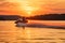 Speed motorboat towing water skier in romantic vibrant sunset. Generative AI