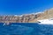 Speedboat at high volcanic cliff of Santorini island
