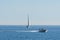 Speedboat overtaking a sailboat on the water of Baltic sea