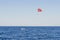 A speedboat pulls a yellow parachute with a tourist. Extreme entertainment for tourists on the sea. Sport activity - Parasailing