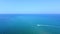 Speedboat sailing on blue tranquil sea and passing next to exotic sandbank beach. Aerial view