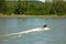 A speedboat traveling upriver against a strong current in the springtime