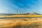 Speeding across train tracks looking out over sunny fields. Wind farms in the distance