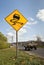 Speeding car passing slippery road sign