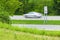 Speeding Car Streaks By Speed Limit Sign