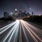 Speeding cars blur against illuminated city skyline backdrop