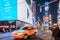 Speeding Taxi in New York City Times Square. Big Animated LED Screens and Toshiba Tower in Background