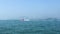 Speedy motor boat floating on blue sea on car bridge and cityscape background. Ships and boats swimming in sea. Mountain