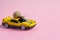 Speedy snail like car racer. Concept of speed and success. Concept of fast taxi or delivery. Yellow car pink background