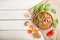 Spelt dinkel wheat porridge with vegetables and mushrooms in wooden bowl on a white wooden background and linen textile. Top