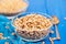 Spelt in glass bowl on blue wooden background