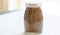 Spelt grains neatly stored in a glass jar against a clean white background, illustrating food storage