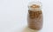 Spelt grains neatly stored in a glass jar against a clean white background, illustrating food storage