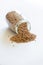 Spelt grains neatly stored in a glass jar against a clean white background, illustrating food storage