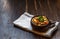 Spelt porridge with vegetables in a brown bowl on a wooden rough Board, with space