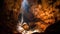 Spelunkers in a colossal cave with light and waterfall from above.