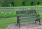 Spend relaxing time on a dark colored iron bench in public garden