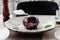 Sphere shaped mousse glazed dessert, cheesecake with chocolate and mint on the white plate. Delicious dessert for holiday