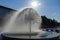 Spherical fountain spraying water in city park. Transparent splash in form ball.