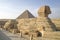 Sphinx Sideview Closeup againts Great Pyramid, Cairo