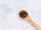 Spice allspice in wooden spoon on concrete background