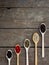 Spice. Black pepper, white, pink, green, cubeb in wooden spoons on a wooden background.