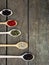 Spice. Black pepper, white, pink, green, cubeb in wooden spoons on a wooden background.