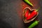 Spice Food dark Background. Red And green hot pepper in a wooden bowl