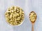 Spice green cardamom Elettaria cardamomum in transparent bowl and wooden spoon on gray concrete background closeup