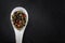 Spice peppercorns in a spoon