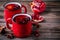 Spiced Pomegranate Apple Cider Mulled Wine Sangria in red mugs on wooden background.