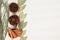 Spices - aniseed, cinnamon, cloves and herbs in wooden bowls on a wood white background.