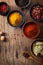 Spices in bowls: pink and black pepper, paprika powder, curry, b