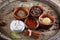 Spices in ceramic bowls on the top of wooden barrel, close-up, selective focus.