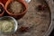 Spices in ceramic bowls on the top of wooden barrel, close-up, selective focus.