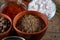 Spices in ceramic and glass bowls on the top of wooden barrel, close-up, selective focus.