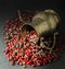 Spices; pepper white, pink, black, scented, brass jug on dark background