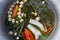 Spices preparation for canning. Red pepper, garlic, dill, horseradish, cilantro are inside of an aluminum basin filled with a clea