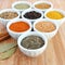 Spices in white bowls â€“ Basil in the foreground