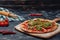 Spicy appetizing Neapolitan pizza on board with cherry tomatoes and chilli, free space for text