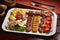 Spicy bbq Mixed Grills platter with tikka boti kababs, fries, salad served in dish isolated on table side view of middle east food