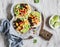 Spicy bean tostadas with corn salsa and avocado on a light background, top view.