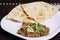 A spicy beef keema mince on a plate with roti.