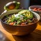 Spicy black bean soup garnished with sour cream, diced avocado, and fresh cilantro