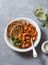 Spicy braised lima beans in tomato sauce and ciabatta toast on a grey background.Delicious vegetarian lunch vegetable protein