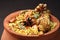 Spicy chicken biryani in traditional handi or clay pot.