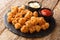 Spicy Chicken popcorn breaded deep fried served with two sauces close up on a slate board. horizontal