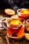 Spicy citrus hot tea with ginger, cloves, cinnamon and orange slices, delicious, warming and healthy in glass cups