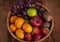 Spicy fruit salad on banana leaf in black dish on Rattan background.